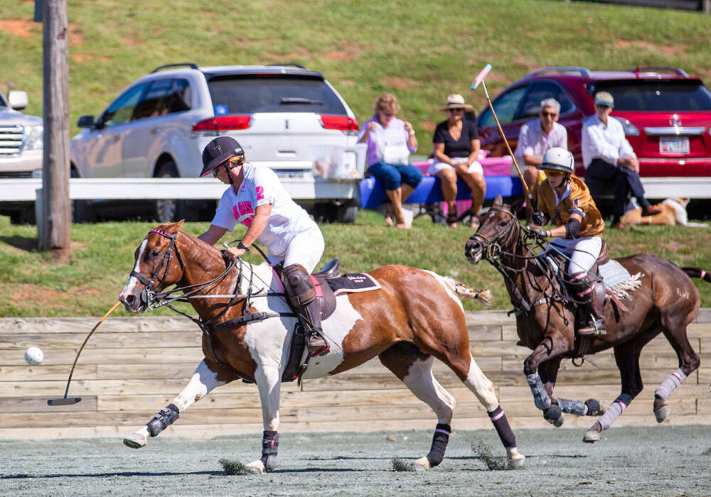 Bad Ass Polo's Posey Obrecht hits the forehand as La Jefa's Katie Mitcham charges from behind.