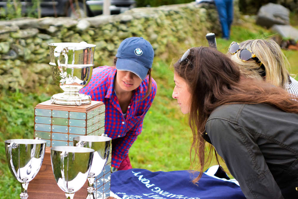 Polo fans and competitors inspect the inscriptions on the George Carter Sherman Memorial Indoor Polo Cup.