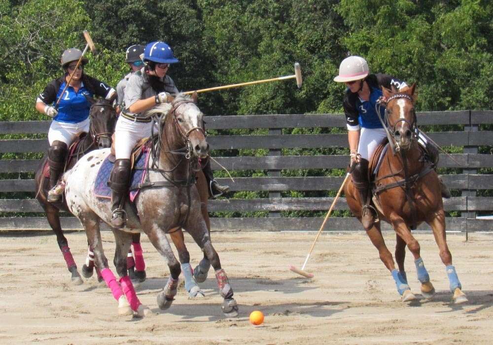 Rebellis' Kasey Morris reaches for the ball alongside Old Farm Vet's Sierra Goff on Best Playing Pony Pandora.