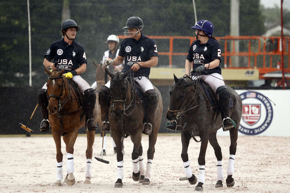 The victorious USA team (Liam Lott, Christian Aycinena and Demitra Hajimihalis) walk out of the arena on a rainy day in Wellington.