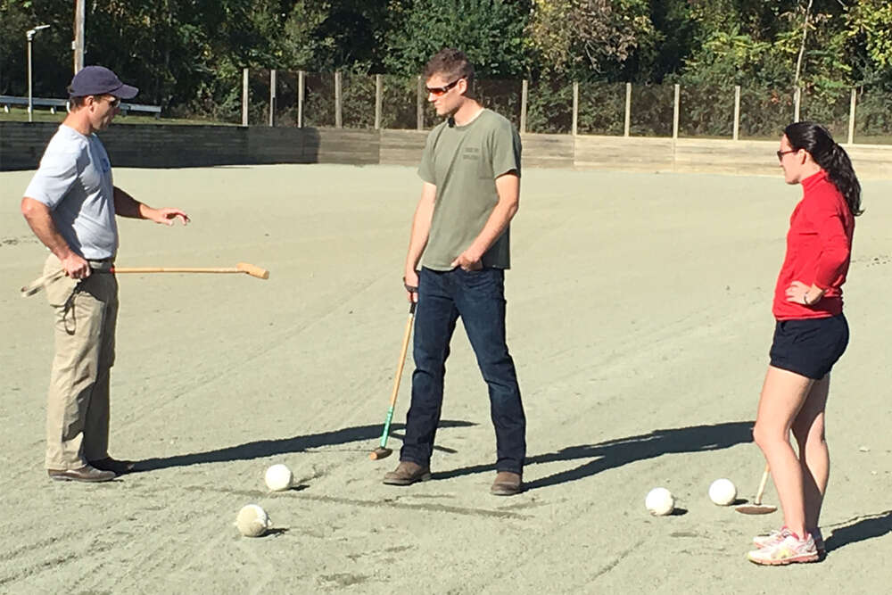 UVA grads and respective clinic team captains Jake Flournoy and Vicky Friedrichs instruct Brian Whaley, Ensign USN (center) in proper mallet technique web