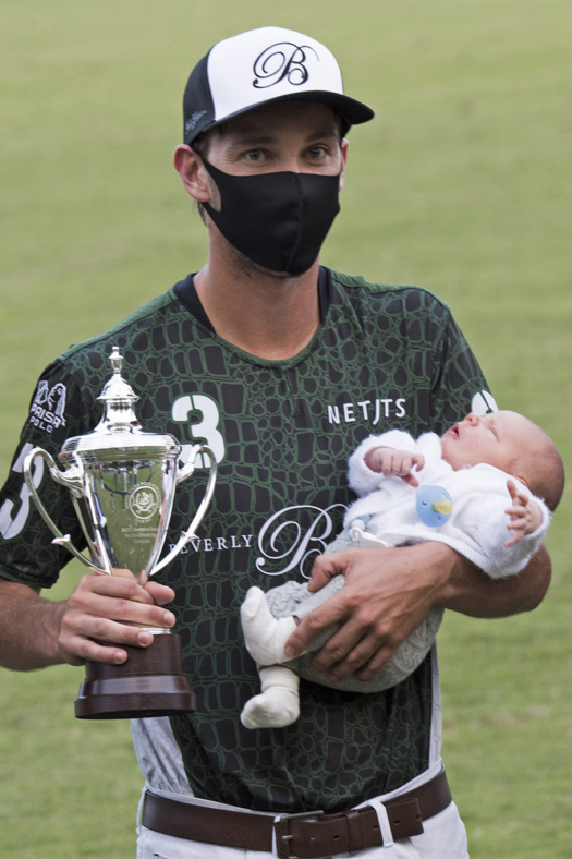 Most Valuable Player Tolito Fernandez Ocampo Jr. poses with his week-old son Cruz. ©Joanne Maisano